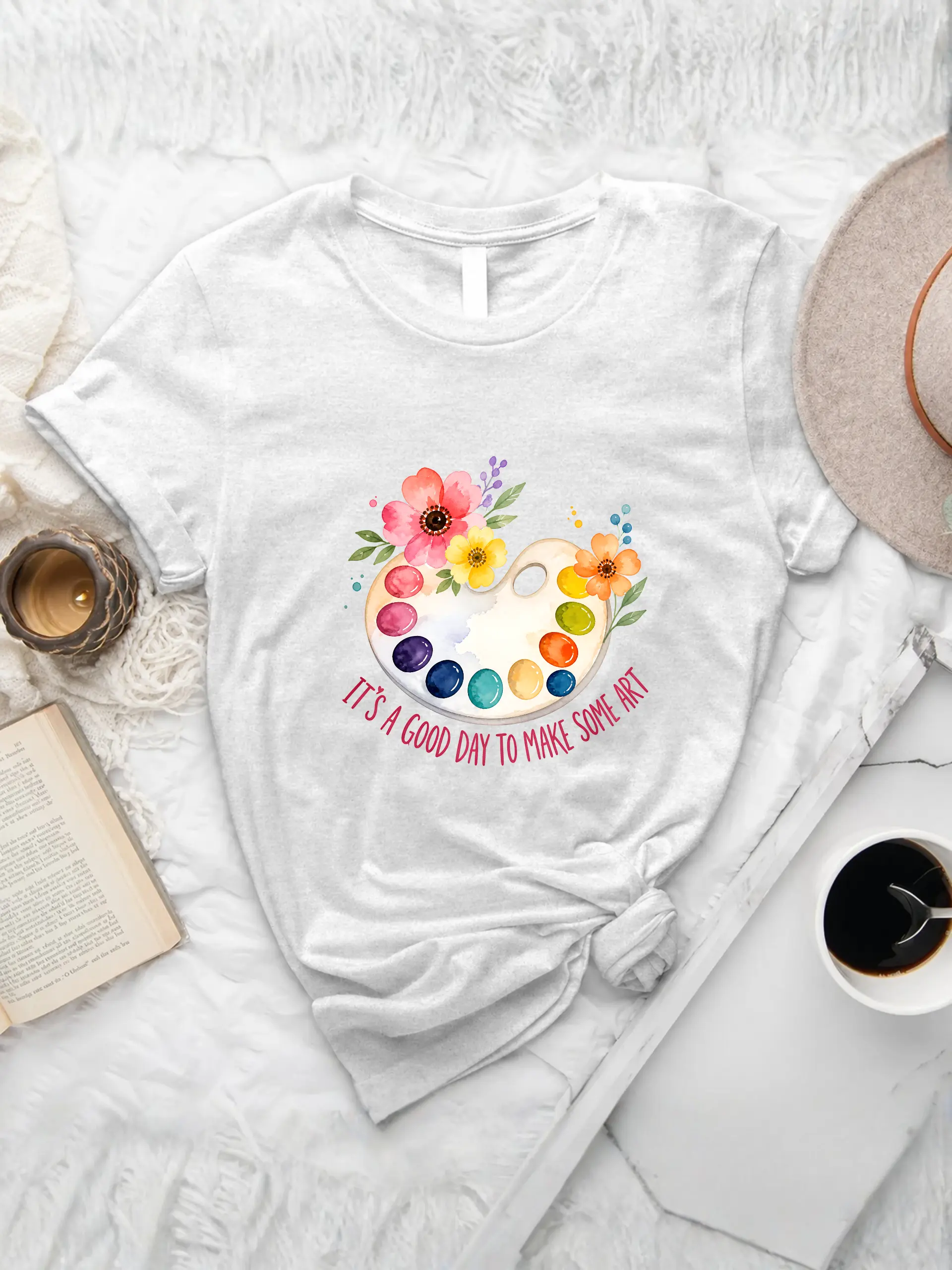 It's A Good Day To Make Art T-shirt with a colorful watercolor palette and floral design on a white heather tee